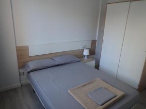 Dormitorio pequeño con cama y espejo en Apartaments L´AMFORA, en Tossa de Mar