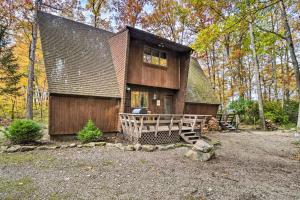 a large wooden house with a porch in the woods at Farmington A-Frame with Lake Access and Fire Pit! in Farmington