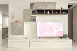 TV de pantalla grande con soporte blanco en una habitación en Attico incantevole - Forum Assago & Humanitas, en Rozzano