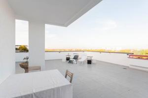 Habitación blanca grande con mesa y sillas en Attico incantevole - Forum Assago & Humanitas, en Rozzano