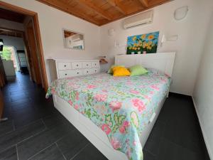 1 dormitorio con 1 cama con colcha de flores en Casa dos Biscoitos, en Praia da Vitória