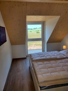 1 dormitorio con cama grande y ventana grande en Ferienhäuser Prüm en Prüm