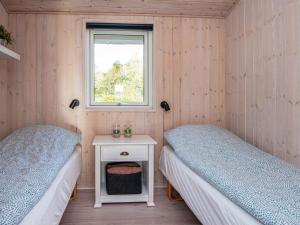 2 Betten in einem Zimmer mit einem Tisch und einem Fenster in der Unterkunft Holiday home Sydals LXXI in Mommark