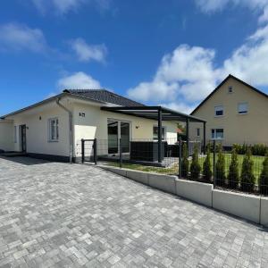 uma casa branca com uma cerca à frente. em Ferienhaus Meerzeit em Bastorf