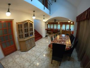 ein Esszimmer mit einem langen Tisch und ein Wohnzimmer in der Unterkunft Totális Harmónia Villa in Miskolctapolca