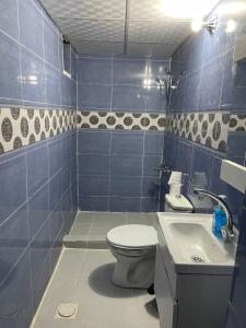 a blue tiled bathroom with a toilet and a sink at Ammar Rum Camp and tours in Wadi Rum +57 photos