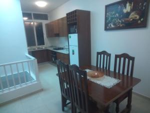 eine Küche mit einem Tisch und Stühlen sowie einem weißen Kühlschrank in der Unterkunft Repousando in Mão para Trás