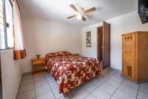 1 dormitorio con 1 cama y ventilador de techo en Hotel Meson de Isabel, en Querétaro