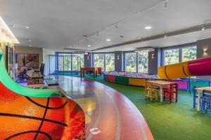 uma grande sala com um parque infantil com um escorrega em Golden Gramado Lagueto Resort em Gramado