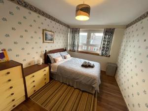 a bedroom with a bed with a pair of shoes on it at West End Hidden Gem - Modern 2-Bedroom Apartment with residents patio in Anniesland