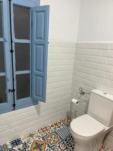 ein Badezimmer mit einem WC und einem blauen Schrank in der Unterkunft Alzira bonita Habitación Azul con baño privado in Alzira