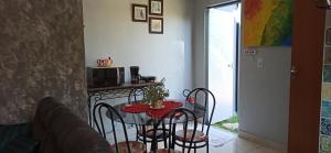 a kitchen with a table with chairs and a microwave at Pousada Casa Bom Sono in Foz do Iguaçu