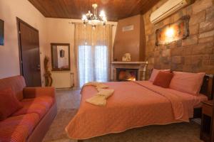 a bedroom with a bed and a couch and a fireplace at Ξενώνας Μαίανδρος in Aridaia