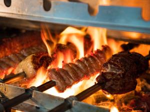 two different types of meat cooking on a grill at Real Intercontinental San Salvador, an IHG Hotel in San Salvador