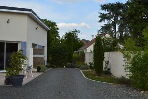 een oprit die leidt naar een huis met een hek bij meublé entier indépendant en contigu de ma maison in Saint-Georges-sur-Moulon