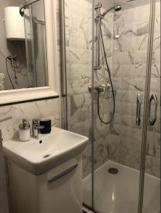 La salle de bains est pourvue d'une douche, d'un lavabo et de toilettes. dans l'établissement Apartament Centrum Zamoyskiego, à Zakopane