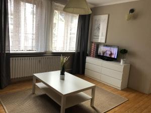 a living room with a coffee table and a tv at Apartament Centrum Zamoyskiego in Zakopane