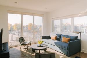 a living room with a blue couch and a large window at Sonder The Lookout in Nashville