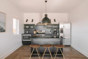 a kitchen with stainless steel appliances and two stools at Sonder The Lookout in Nashville