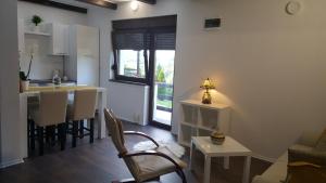 a kitchen and a living room with a table and chairs at Guest House Iva in Slunj