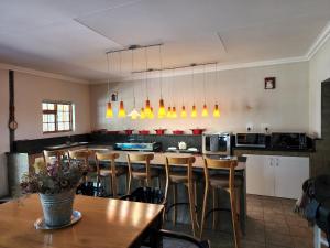 Una cocina con una mesa y sillas en una habitación. en Watervalsrivier Farm, en Prince Albert