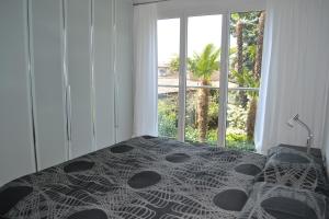 ein Schlafzimmer mit einem Bett und einem großen Fenster in der Unterkunft Bicledro in Ascona