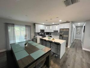a kitchen with white cabinets and a table in it at Breathtaking & Renovated Tampa Heated Pool House in Tampa