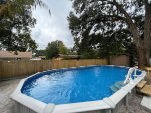 a large swimming pool in a backyard with a wooden fence at Breathtaking & Renovated Tampa Heated Pool House in Tampa