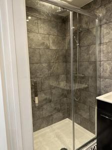 a shower with a glass door in a bathroom at Touchwood in Isleworth