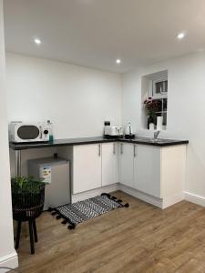 a kitchen with white cabinets and a counter top at Touchwood in Isleworth