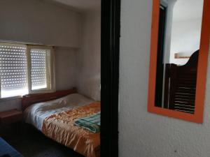 ein kleines Schlafzimmer mit einem Bett und einem Fenster in der Unterkunft Vila Gesell, zona centro y playa in Villa Gesell