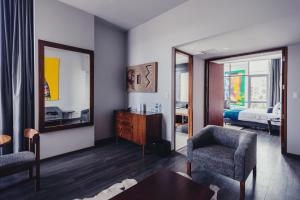 Atix Hotel في لاباز: غرفة معيشة مع طاولة وكرسيين ومرآة