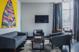 a living room with two chairs and a tv at Atix Hotel in La Paz