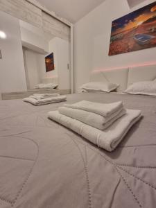 a room with three white towels on a bed at DREAMS ESCAPE in Craiova