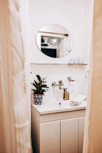 a bathroom sink with a mirror and a potted plant at TurnKey I Studio by City Mall in Prague