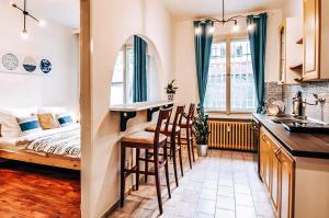 a kitchen with a bar and a bedroom with a bed at TurnKey I Studio by City Mall in Prague