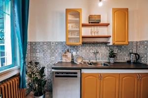 a kitchen with yellow cabinets and a sink at TurnKey I Studio by City Mall in Prague