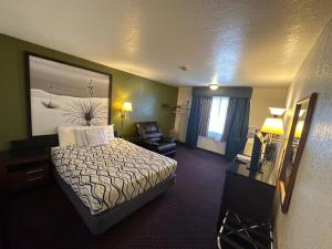 a hotel room with a bed and a chair at Simple Rewards Inn in Ruidoso