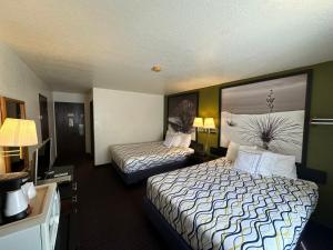 a hotel room with two beds and a television at Simple Rewards Inn in Ruidoso