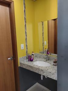a bathroom with a sink and a mirror at Riviera Thermas Park in Caldas Novas