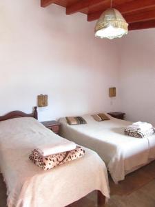 a bedroom with two beds and a chandelier at El mirador de iruya in Iruya