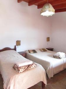 a bedroom with two beds and a chandelier at El mirador de iruya in Iruya
