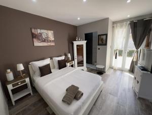 una camera da letto con un grande letto bianco e una televisione di Chez Saliha et Serge a Lamarche-sur-Saône
