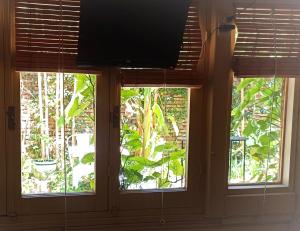 3 ventanas en una habitación con TV de pantalla plana en Colonia Suite Apartments, en Colonia del Sacramento