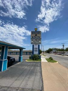 um sinal para uma pousada westin na beira de uma estrada em Western inn em Tulsa