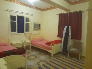 a bedroom with two beds and a window at Grand house in Nag` el-Ramla