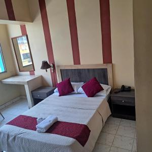 ein Schlafzimmer mit einem großen Bett mit lila Kissen in der Unterkunft Atlantic Suites Hotel in Guayaquil