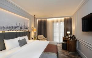 ein Hotelzimmer mit einem großen Bett und einem TV in der Unterkunft Livro Hotel in Istanbul