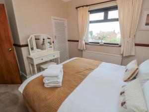 1 dormitorio con cama con espejo y lavamanos en Beachcrest, en Whitby