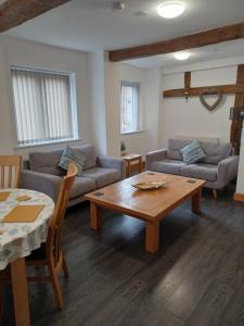 a living room with a couch and a table at Bear Apartments in Rhayader